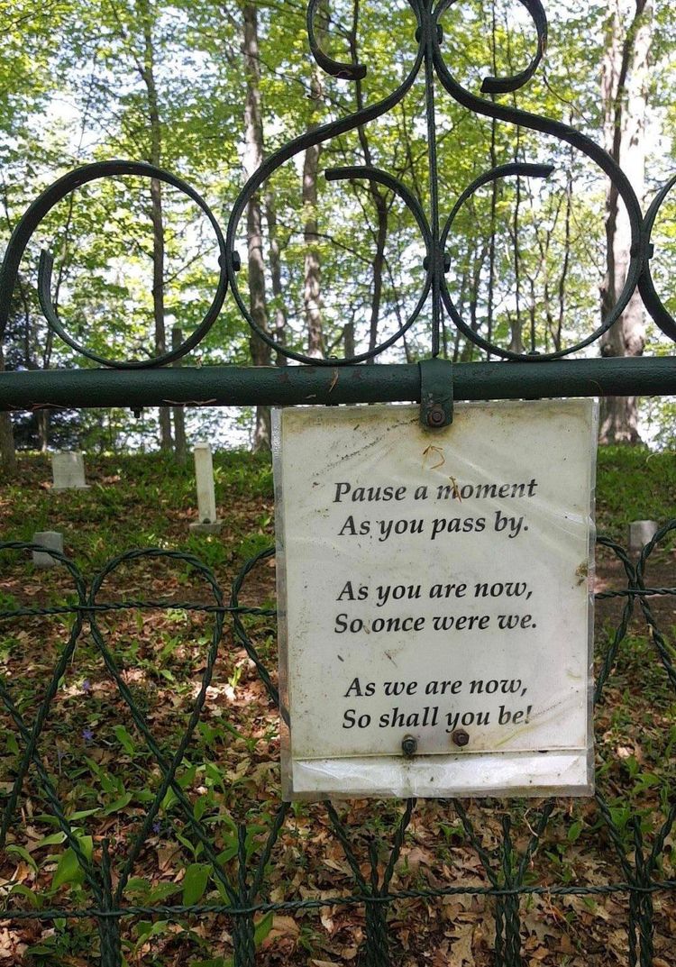 A sign on a fence that reads “Pause a moment / As you pass by. / As you are now, / So once were we. / As we are now, / So shall you be!”